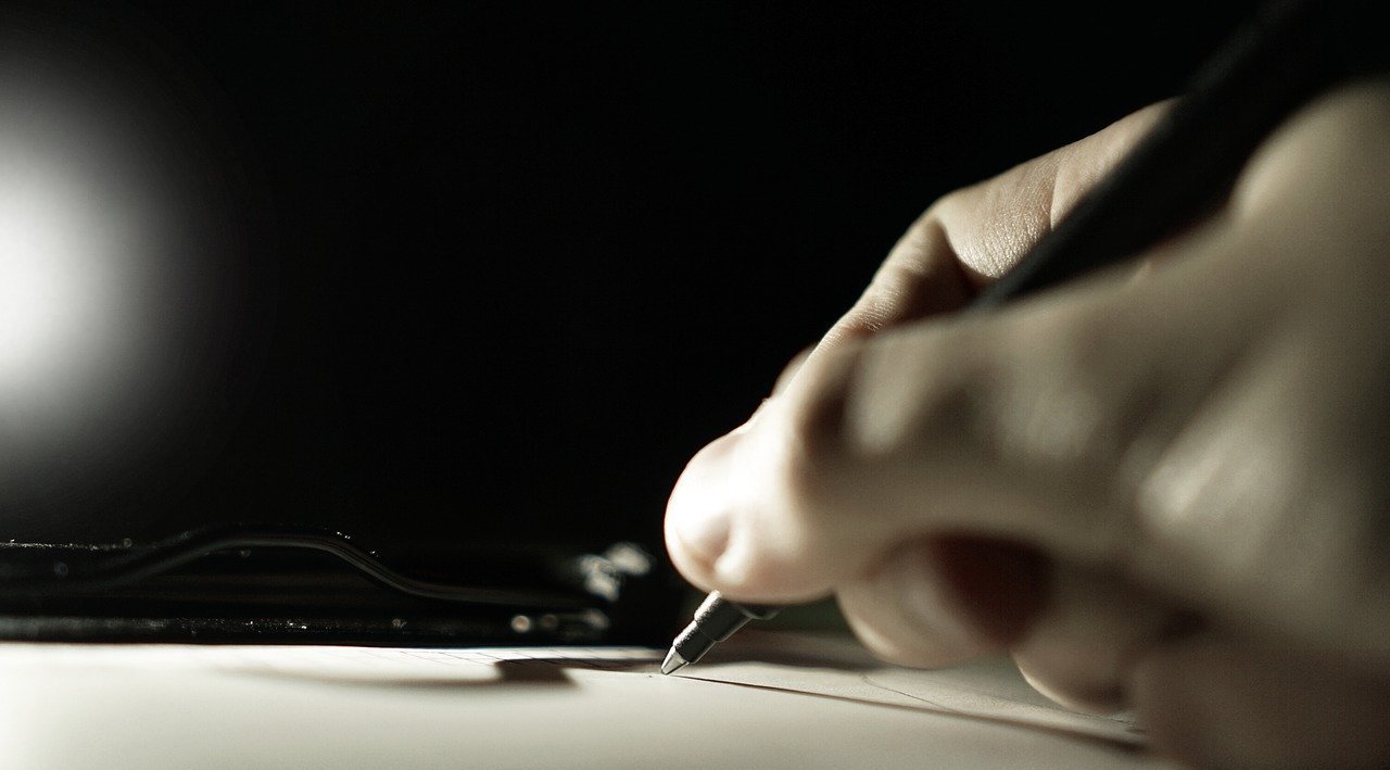 Closeup of a person writing on a piece of paper