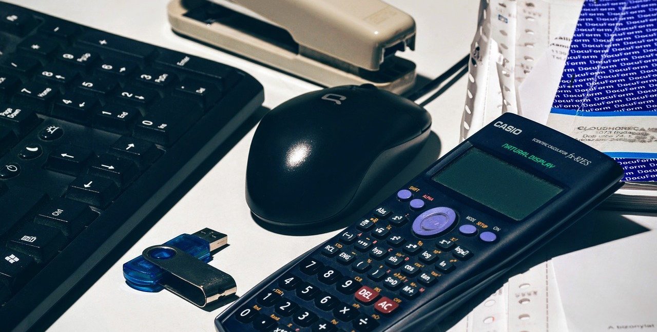 Calculator beside a mouse, and keyboard