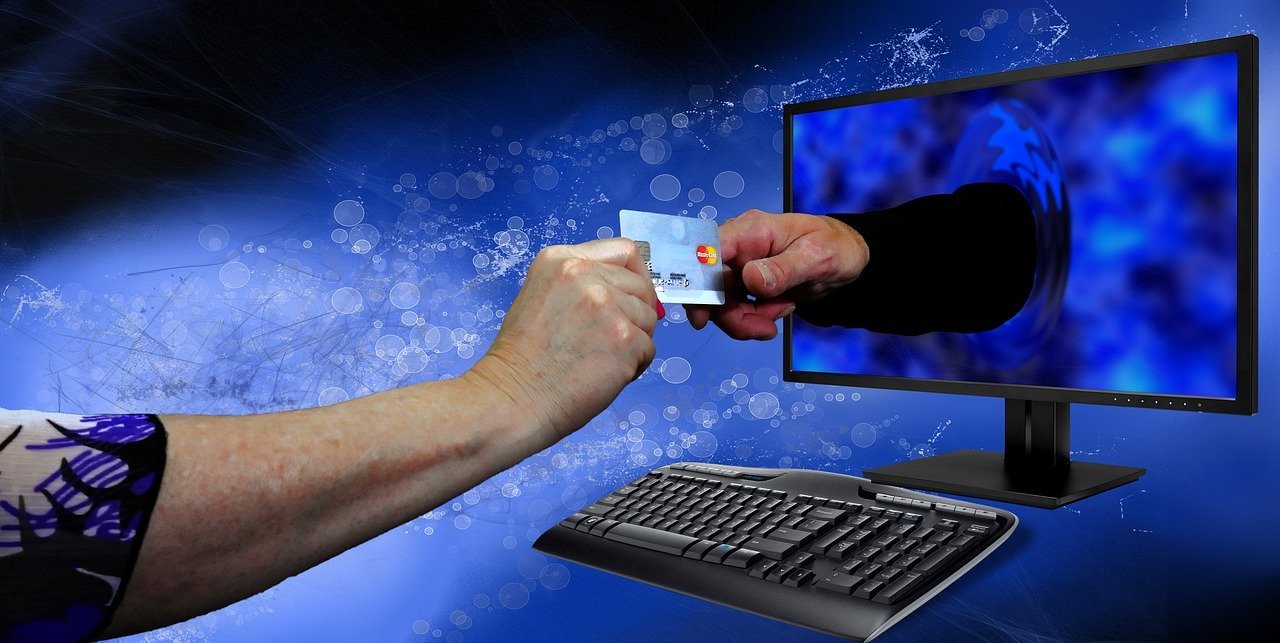 Man handing his credit card on a desktop monitor