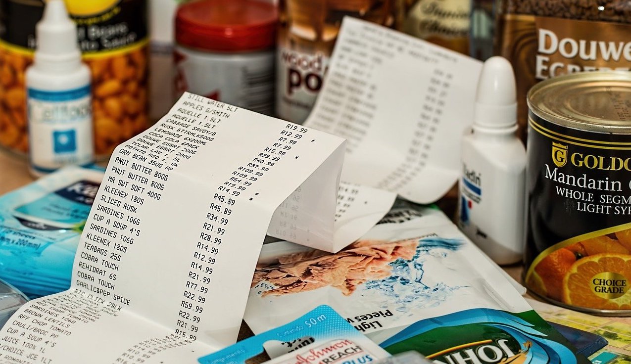 Long grocery receipt with products purchased visible on the table