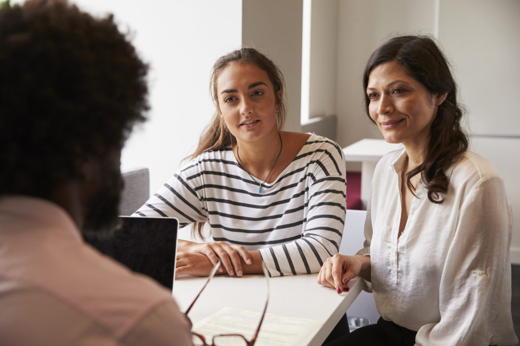 Mother and daughter listening to a bank consultant