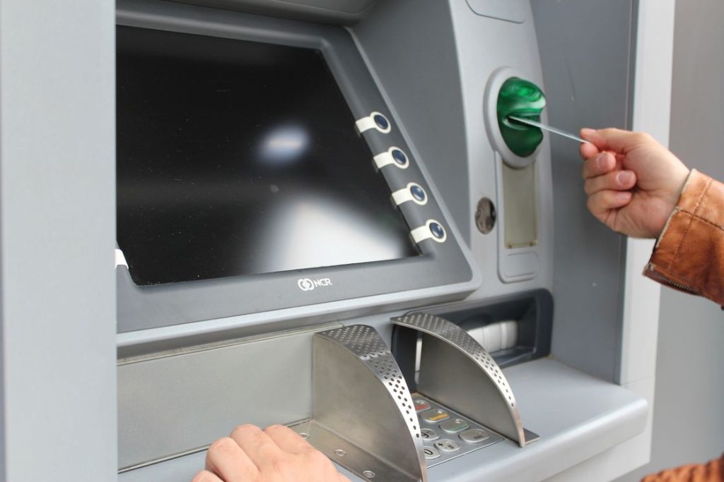 Person placing his card on an ATM machine