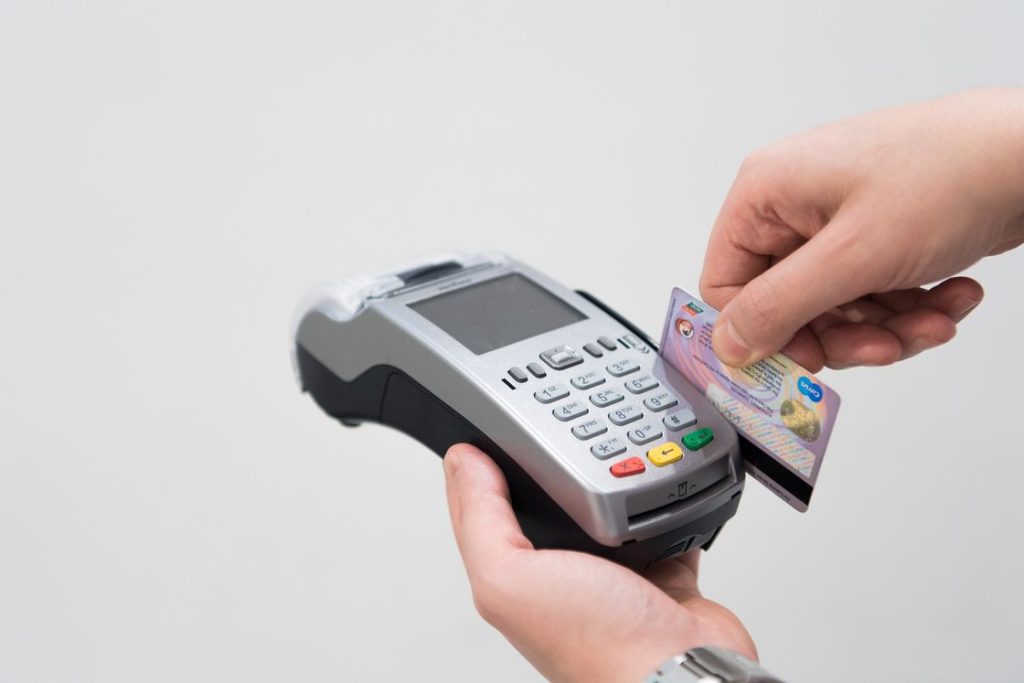Person using a card reader to swipe a credit card for payment