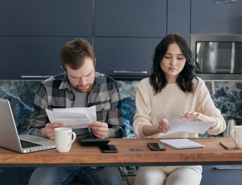 Couple reviewing their bills while sitting down on their table