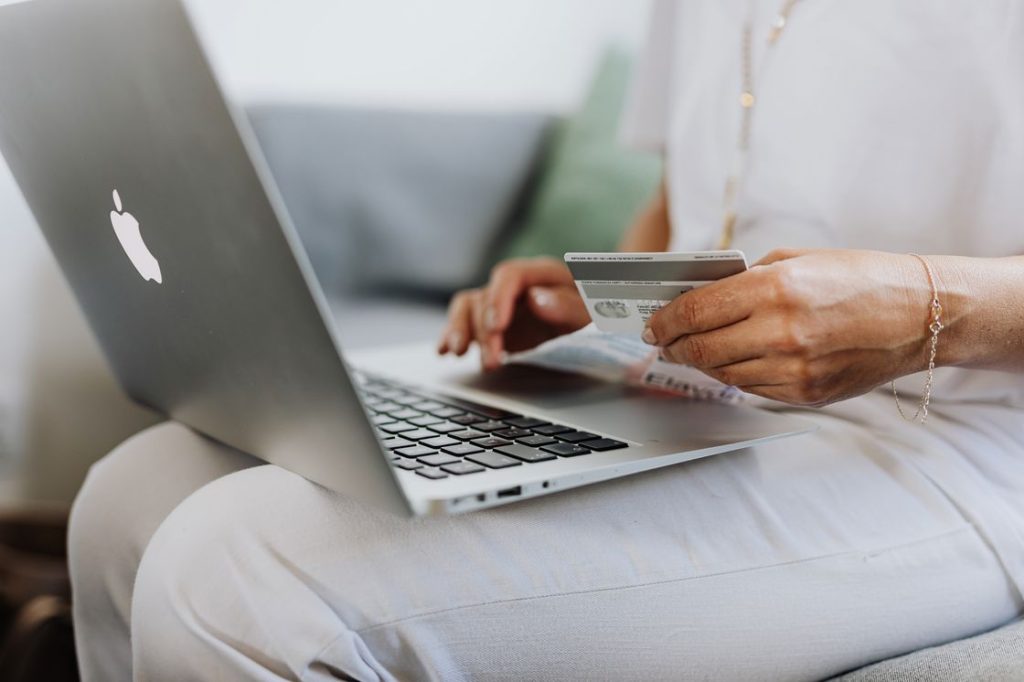 Woman using a laptop while holding a credit card