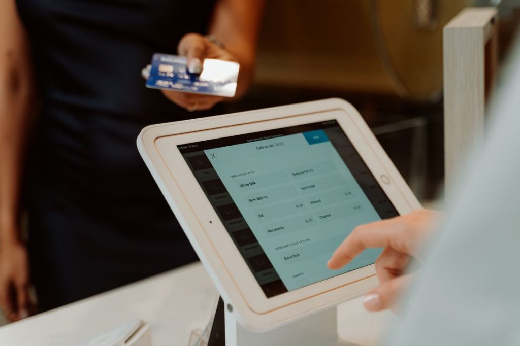 Person handing out their credit card to a cashier