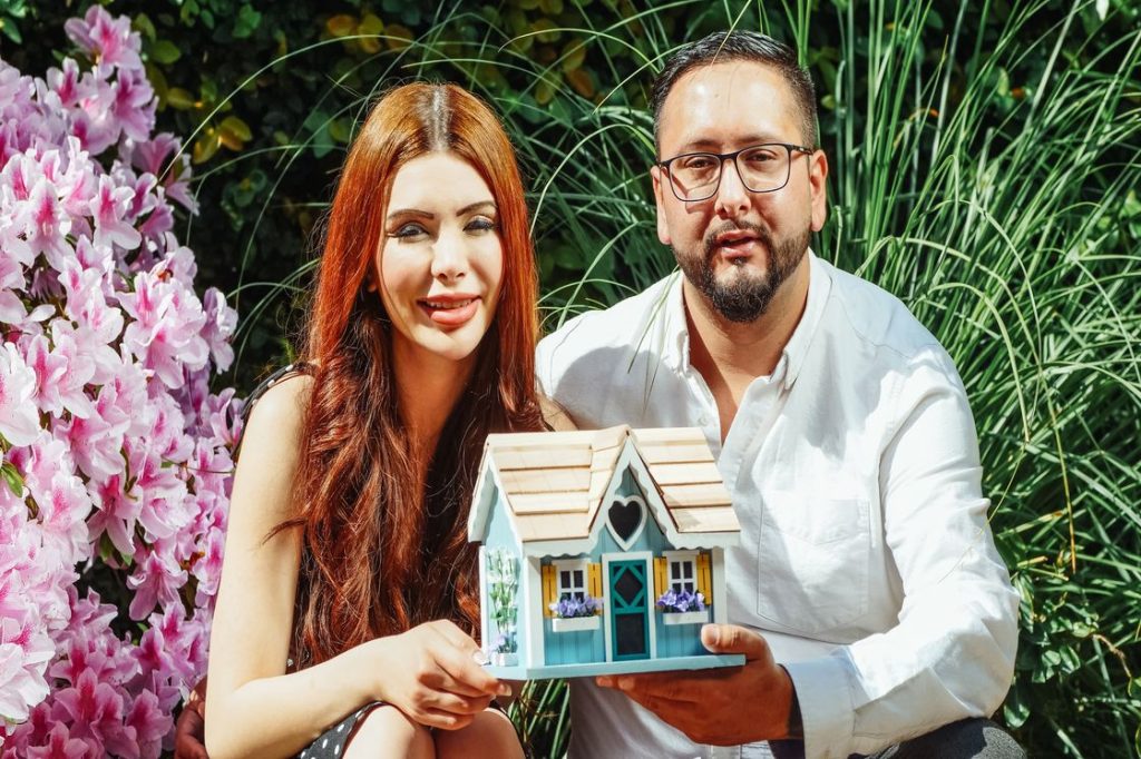 Couple holding a miniature house