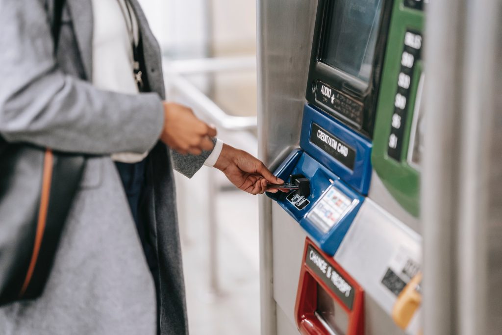 A woman inserting her credit card in an ATM machine