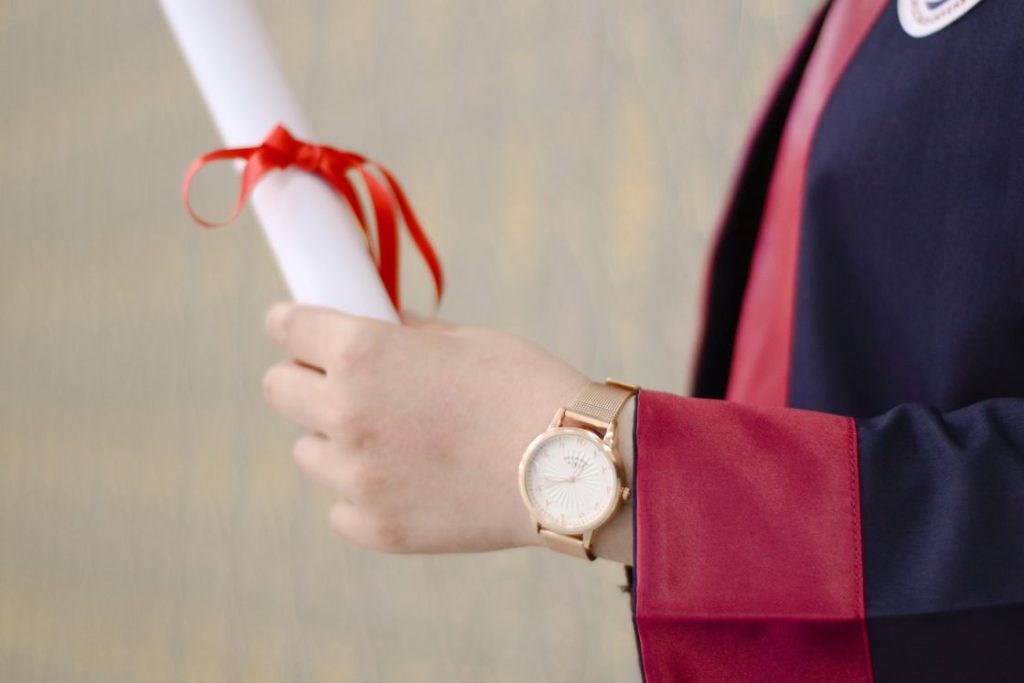 Person holding a diploma while wearing their graduation robes