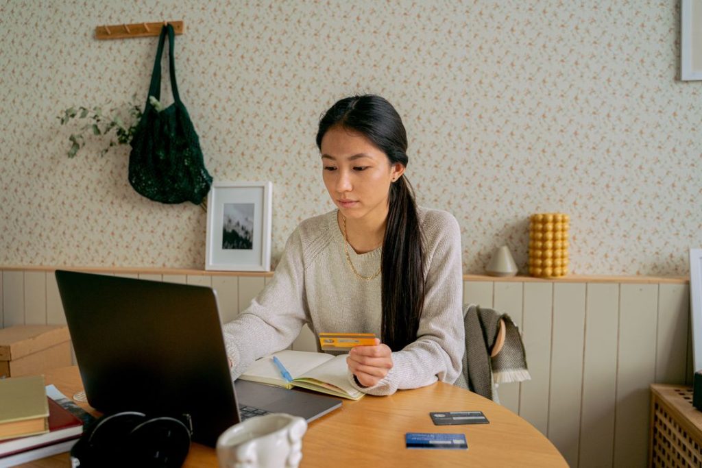 Woman holding a credit card while using her laptop