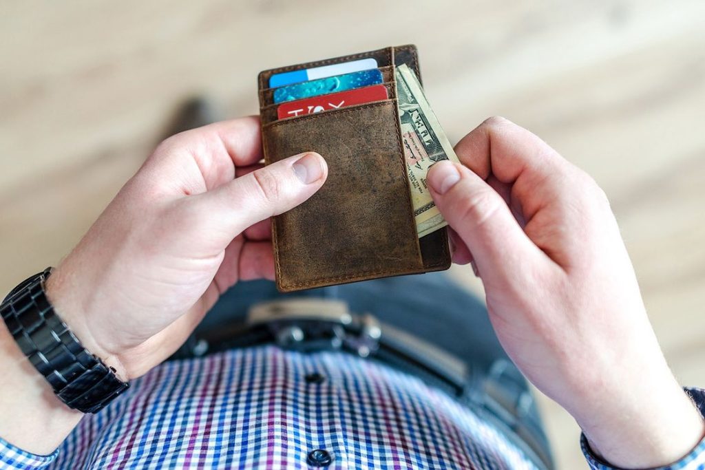 Man taking a dollar bill from his wallet