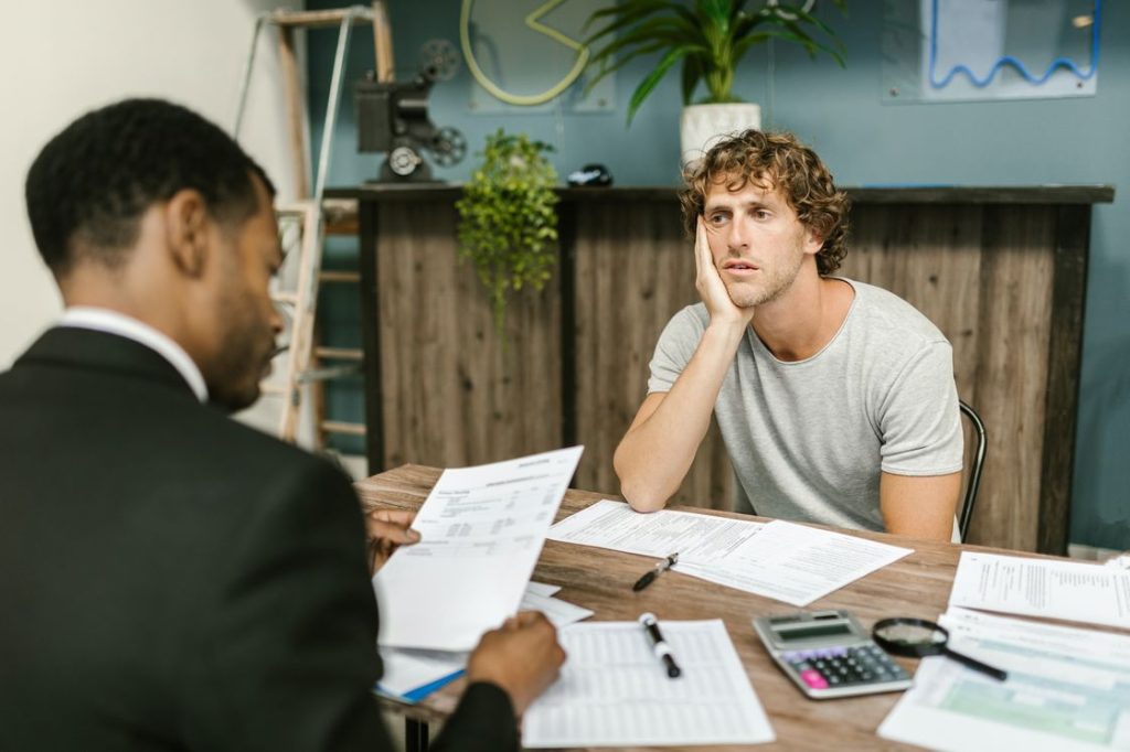 Man listening intently as his financial advisor lists out advice for his credit building