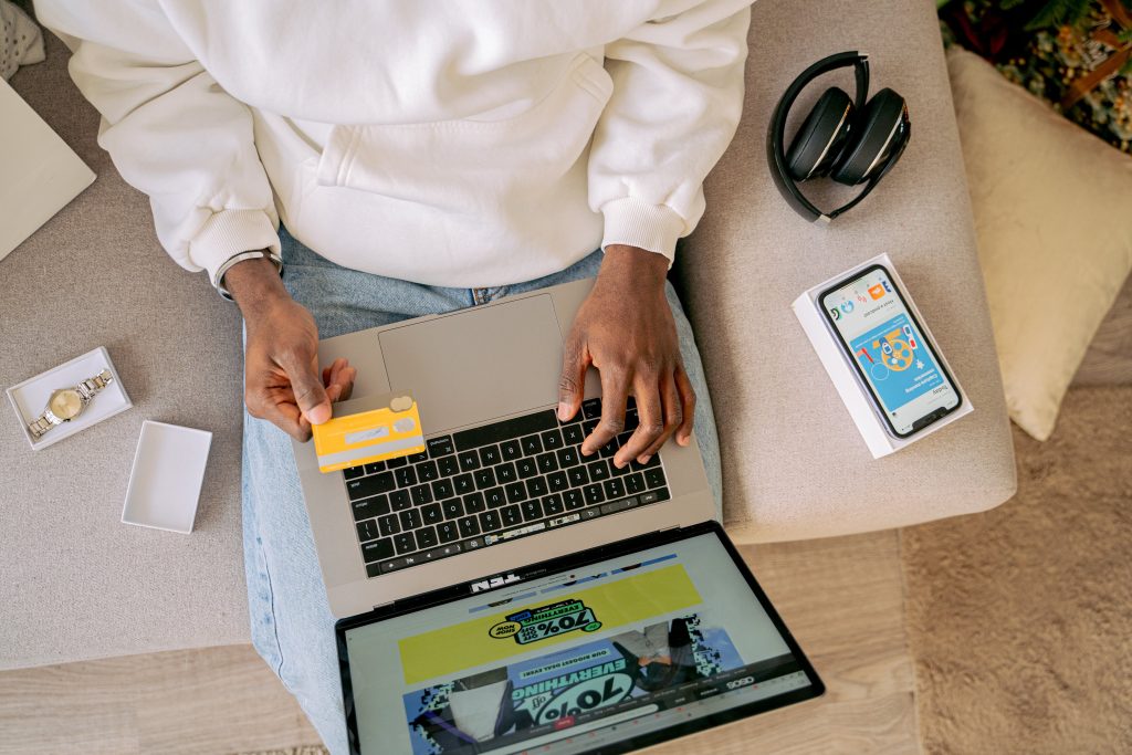 A man shopping online while holding his credit card