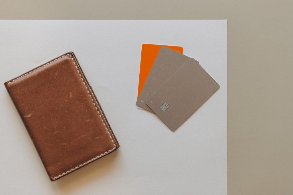 A brown wallet and three credit cards on a table