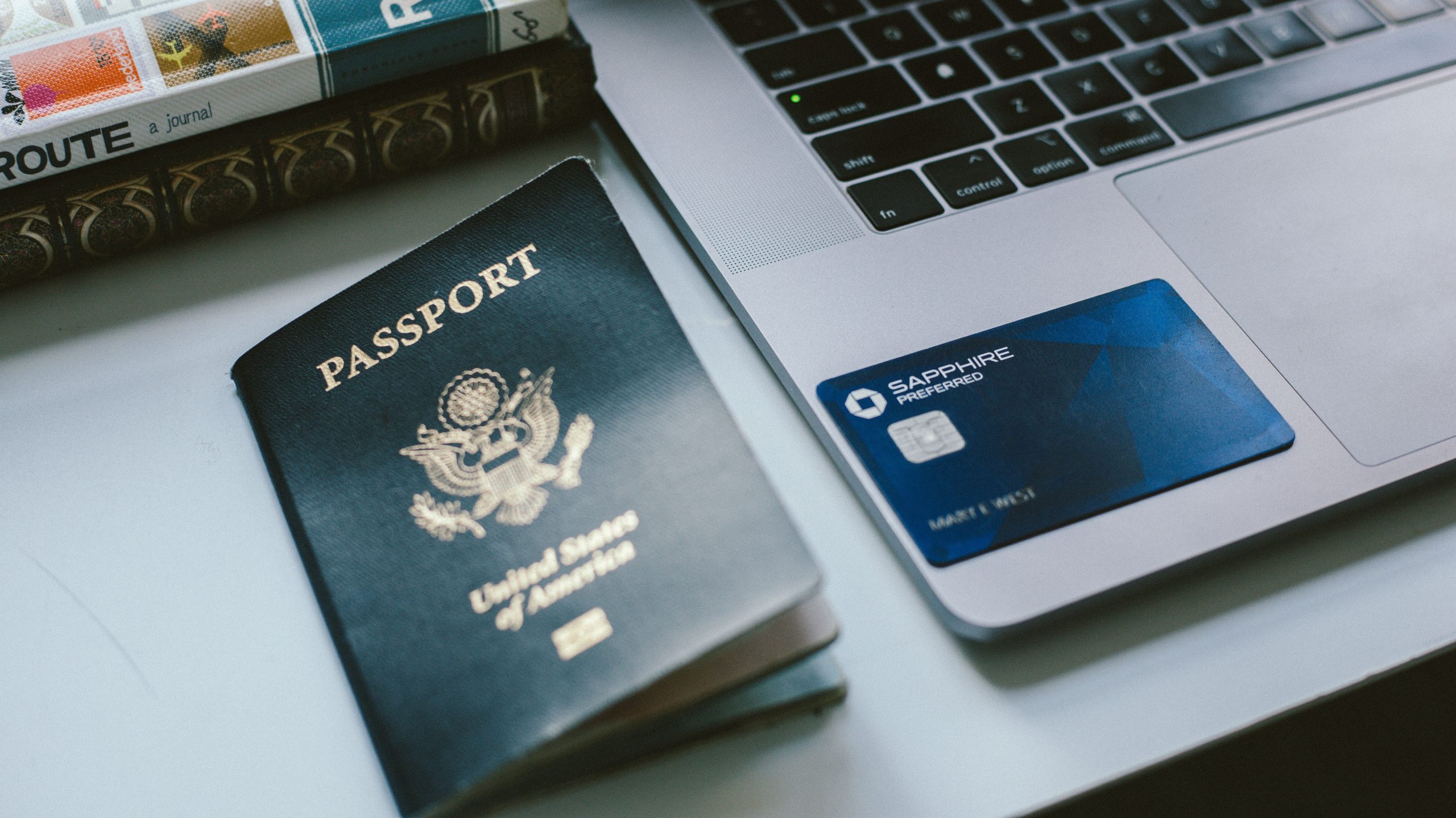 A passport and a Chase Sapphire Preferred card on the laptop