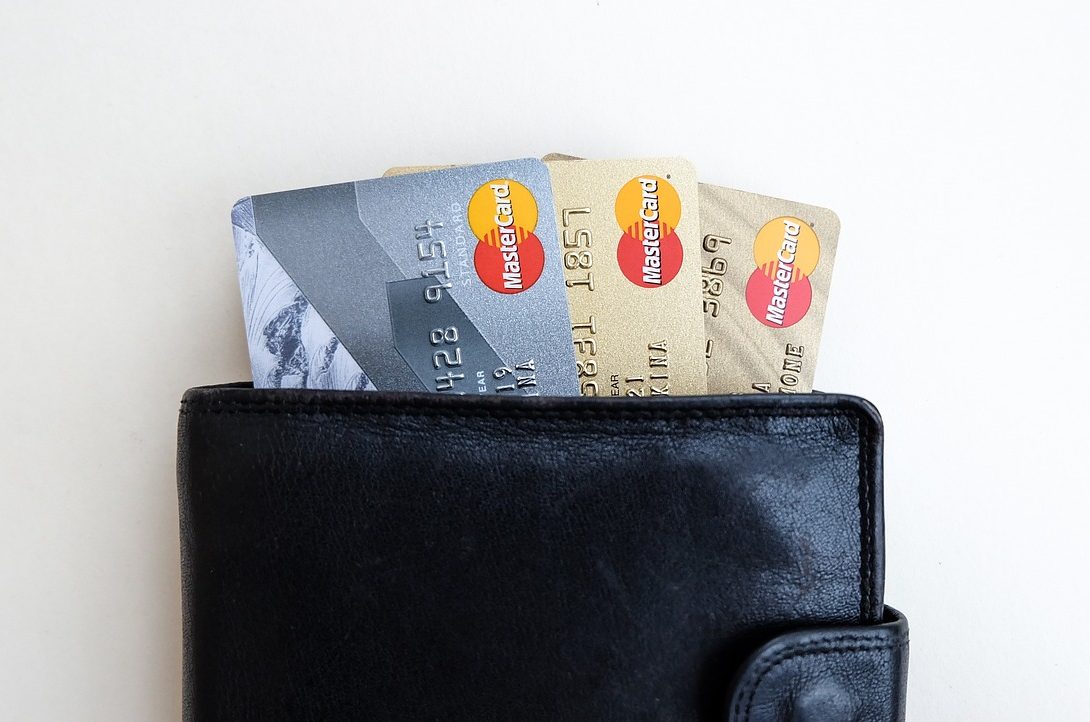 A black wallet with three different credit cards