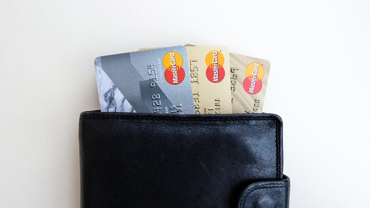 A black wallet with three different credit cards