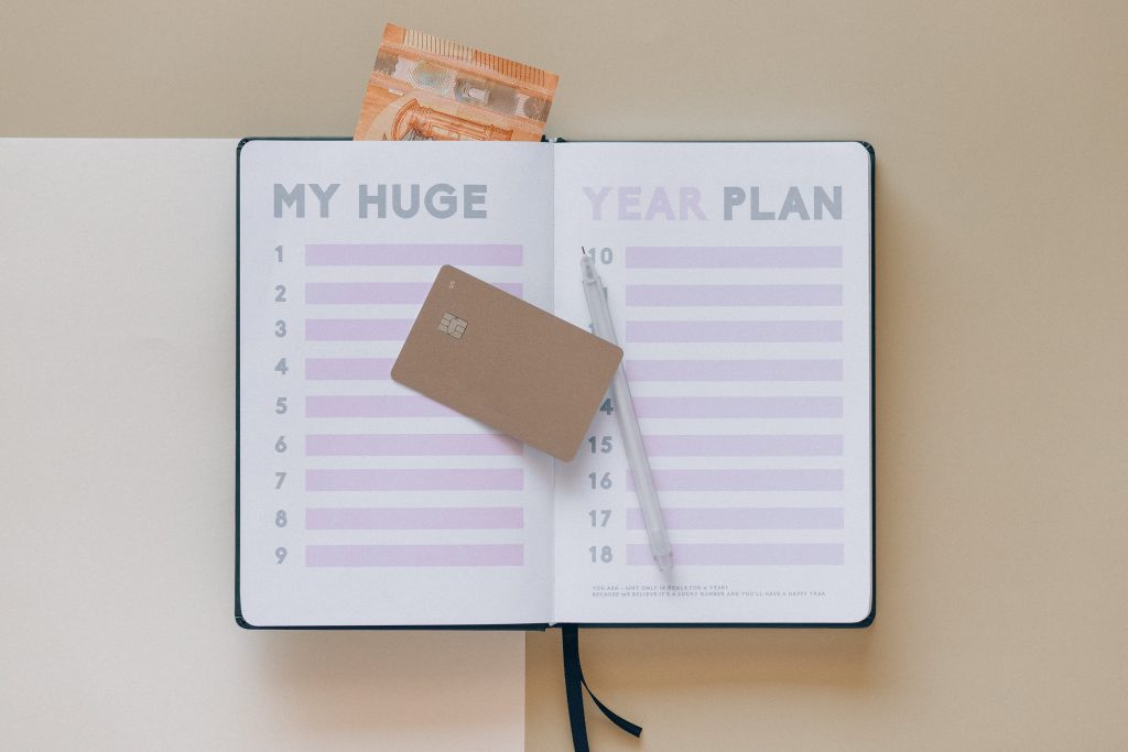 A planner with credit card and pen on top of it
