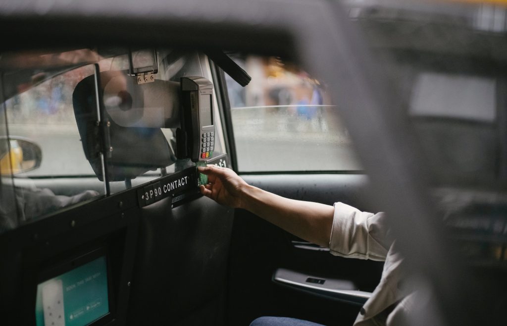 A person swiping a credit card on a terminal payment on a car