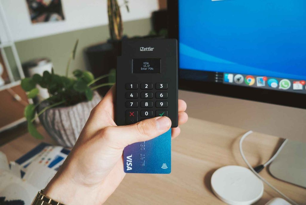 Person holding a portable payment terminal with a credit card inside