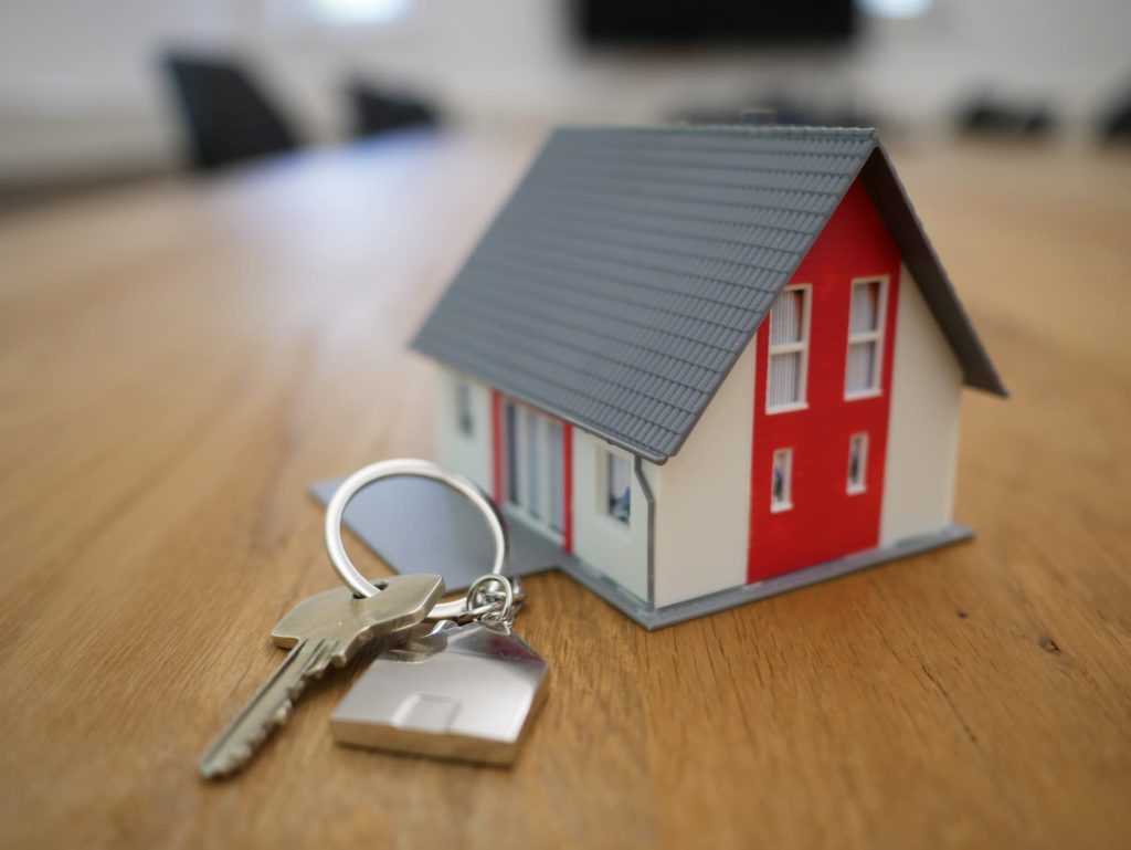 Miniature wooden house and keys on a table