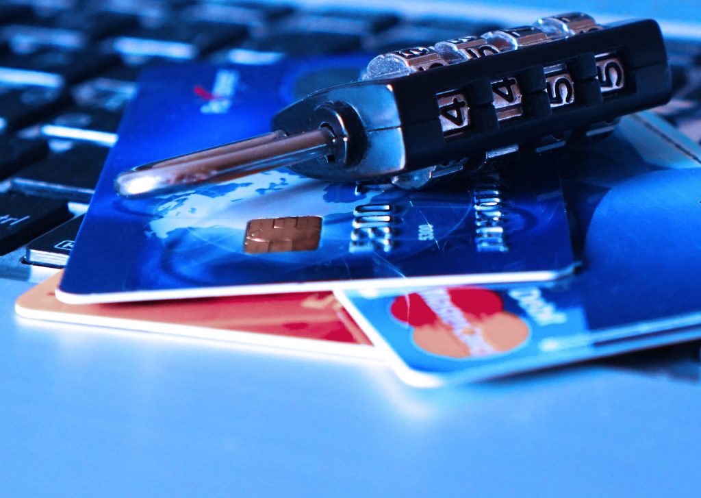 A lock and three credit cards on top of a laptop