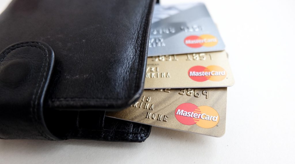 An image of a black wallet with three credit cards