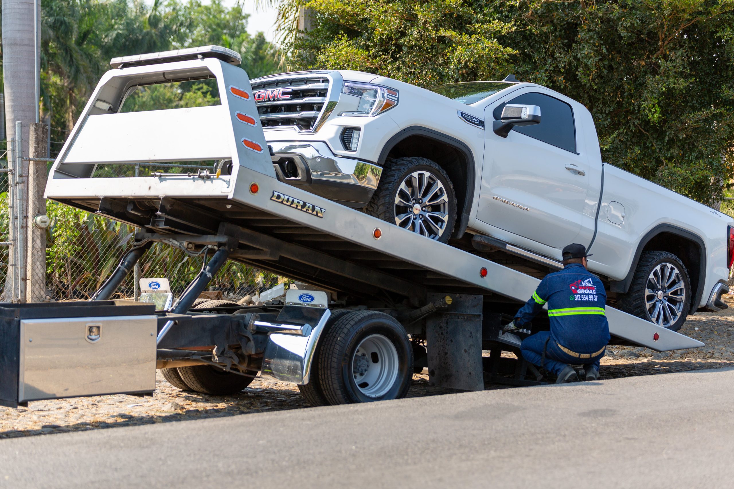 A man towing a pick up on his tow truck