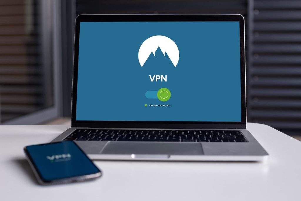 Laptop screen and phone showing the logo of a VPN brand