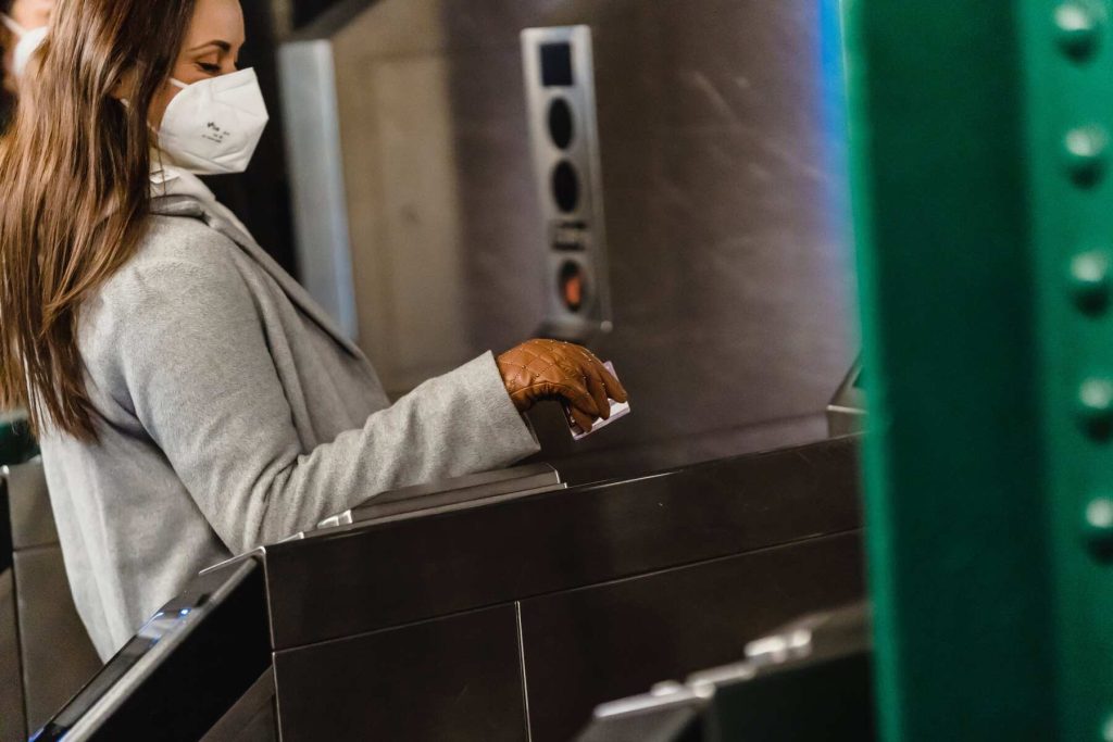 A woman swiping her card on the entrance of a subway