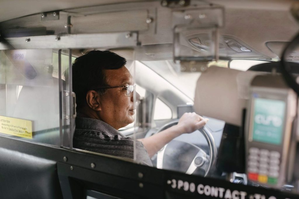 A driver with his terminal payment on the rear passenger seat