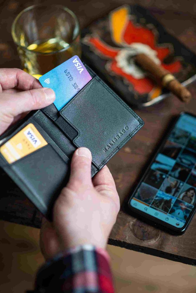 A man with a black leather wallet with two credit cards