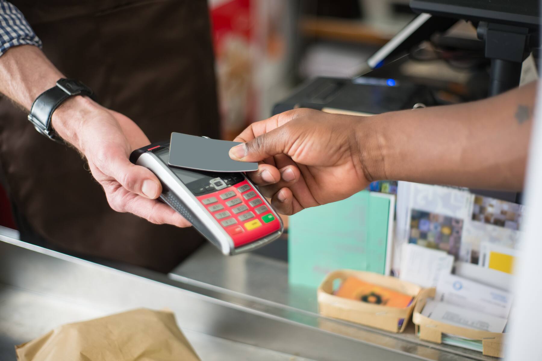 A customer swiping his credit card on a terminal payment on a grocery store