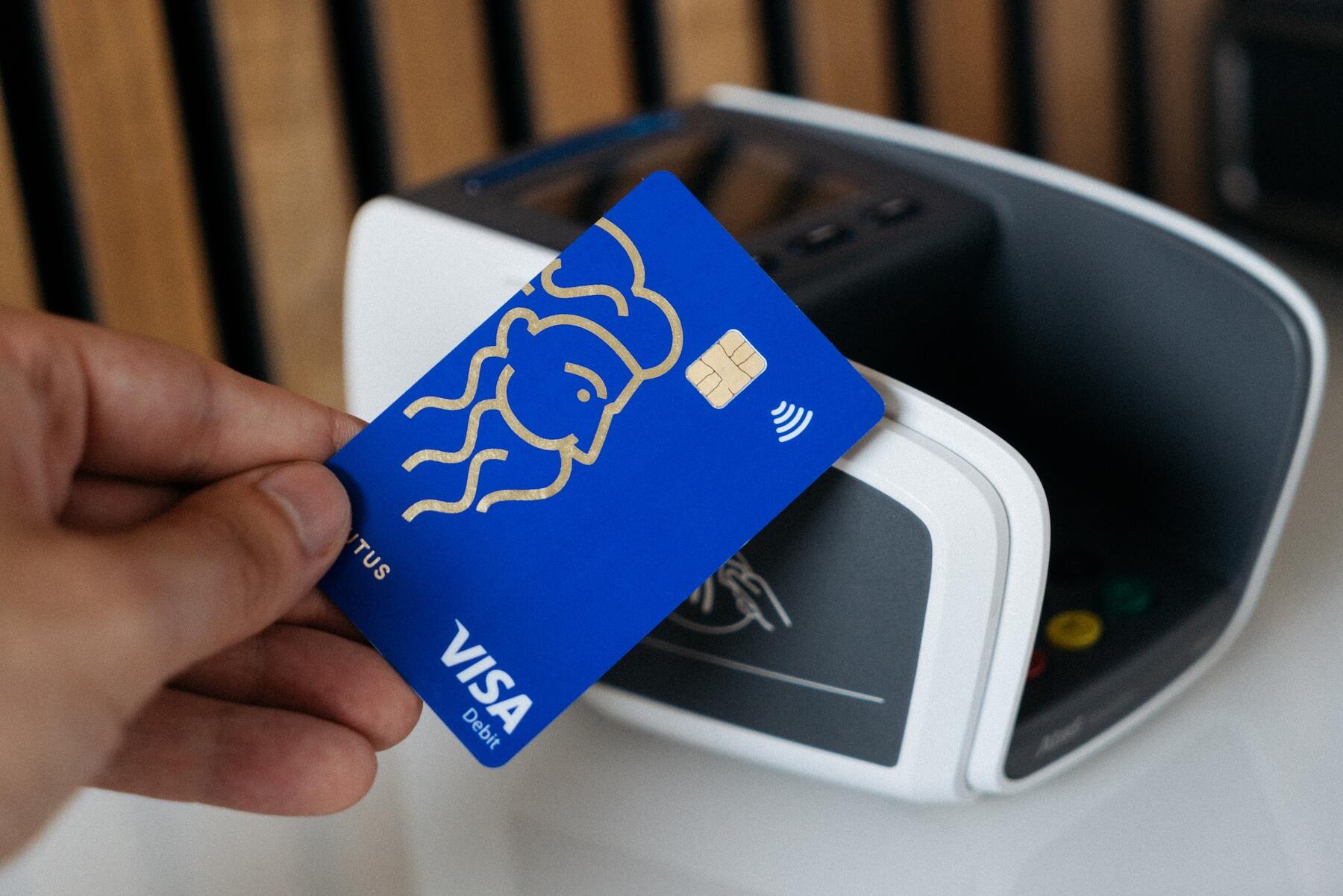 A blue credit card being tapped on a payment machine