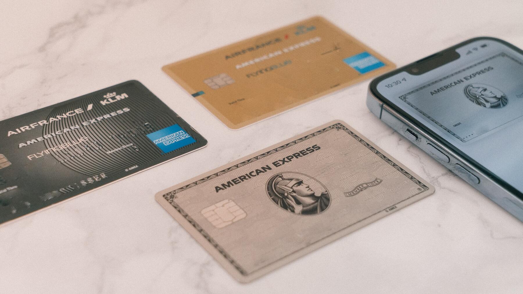 Various credit cards and a mobile phone on a marble surface