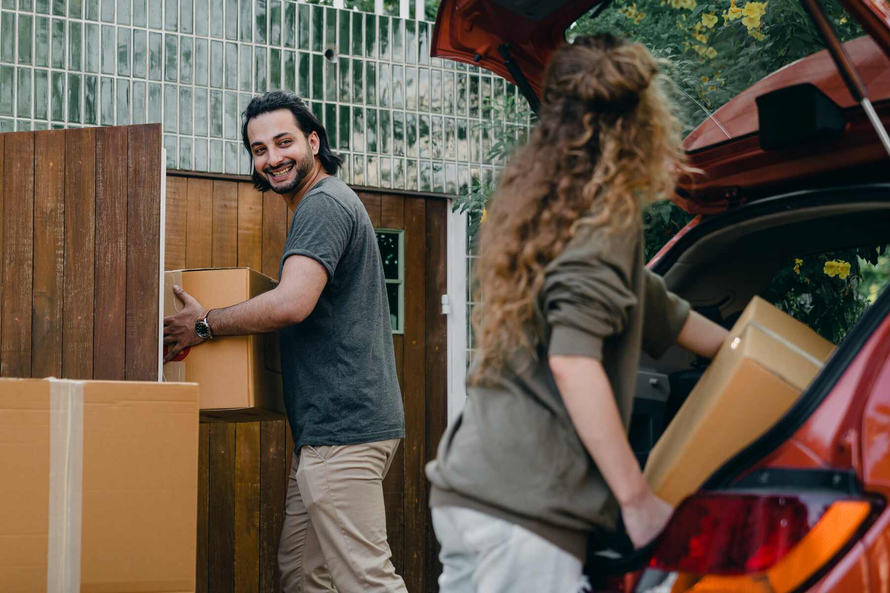 Couple moving boxes from their car