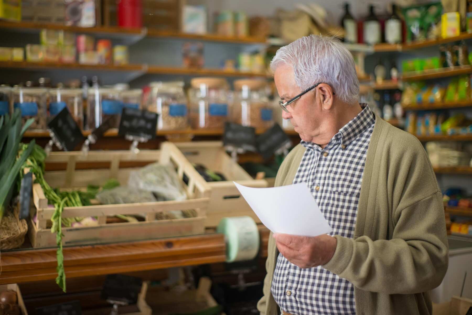 Senior holding a list while grocery shopping