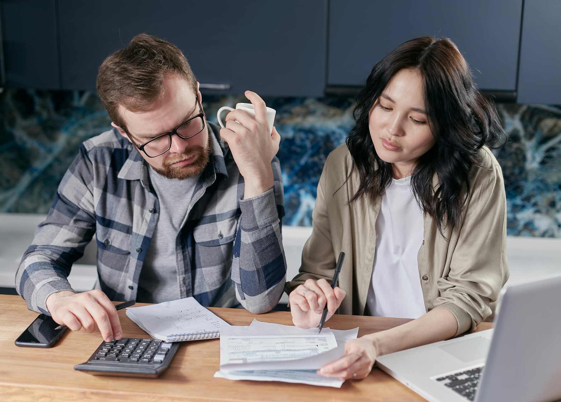 Couple reviewing their credit card bill while calculating the fees