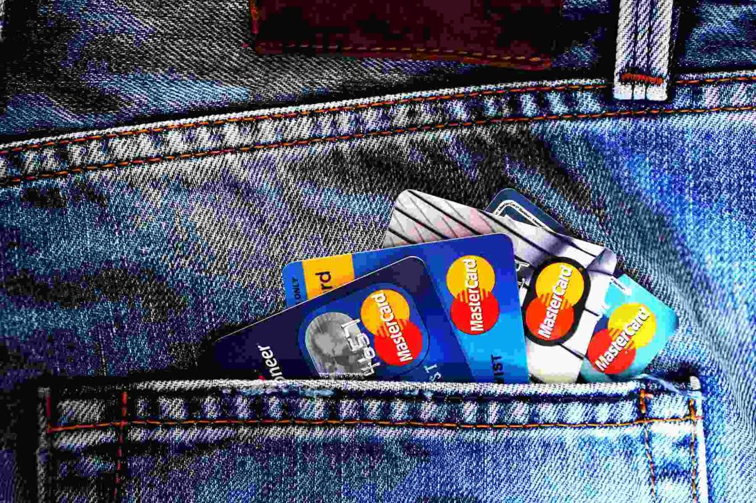Various credit cards placed on the back pocket of a person's jeans