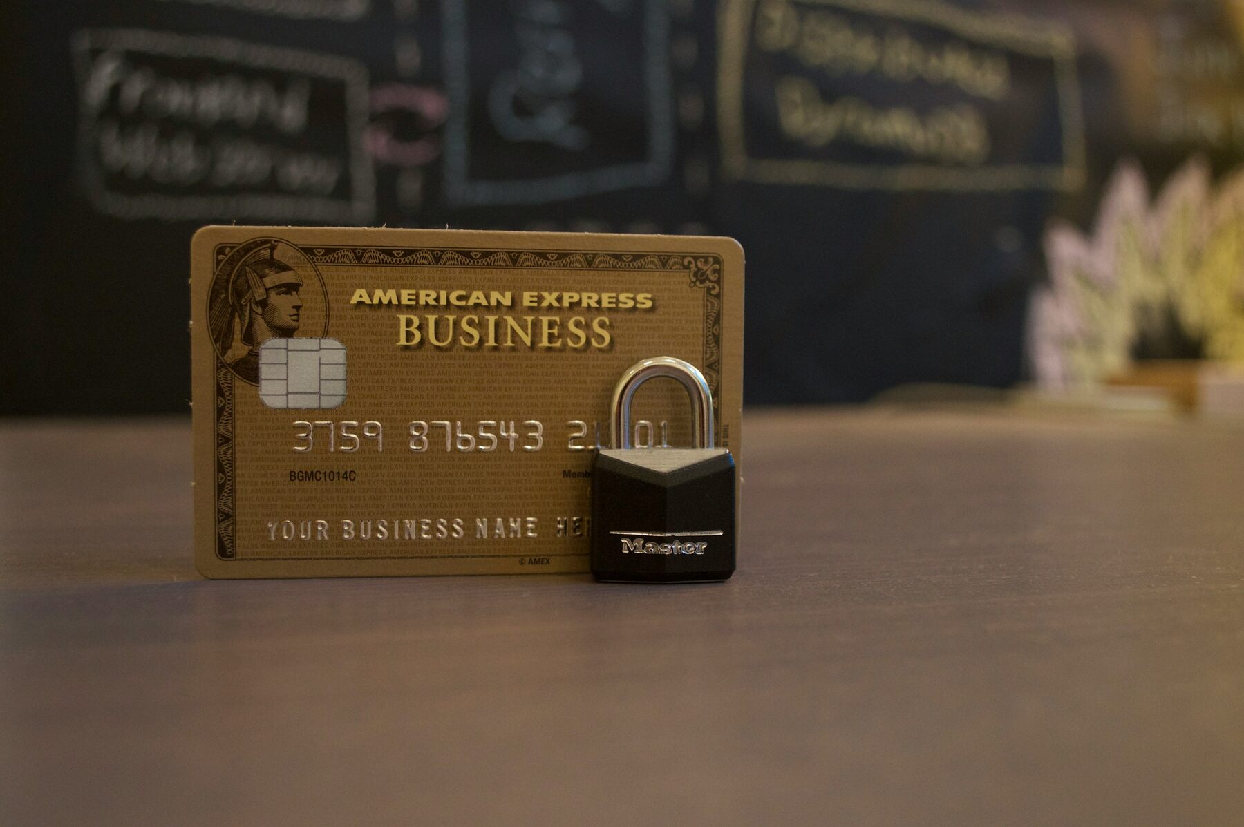 A gold business credit card with a lock on a dark surface