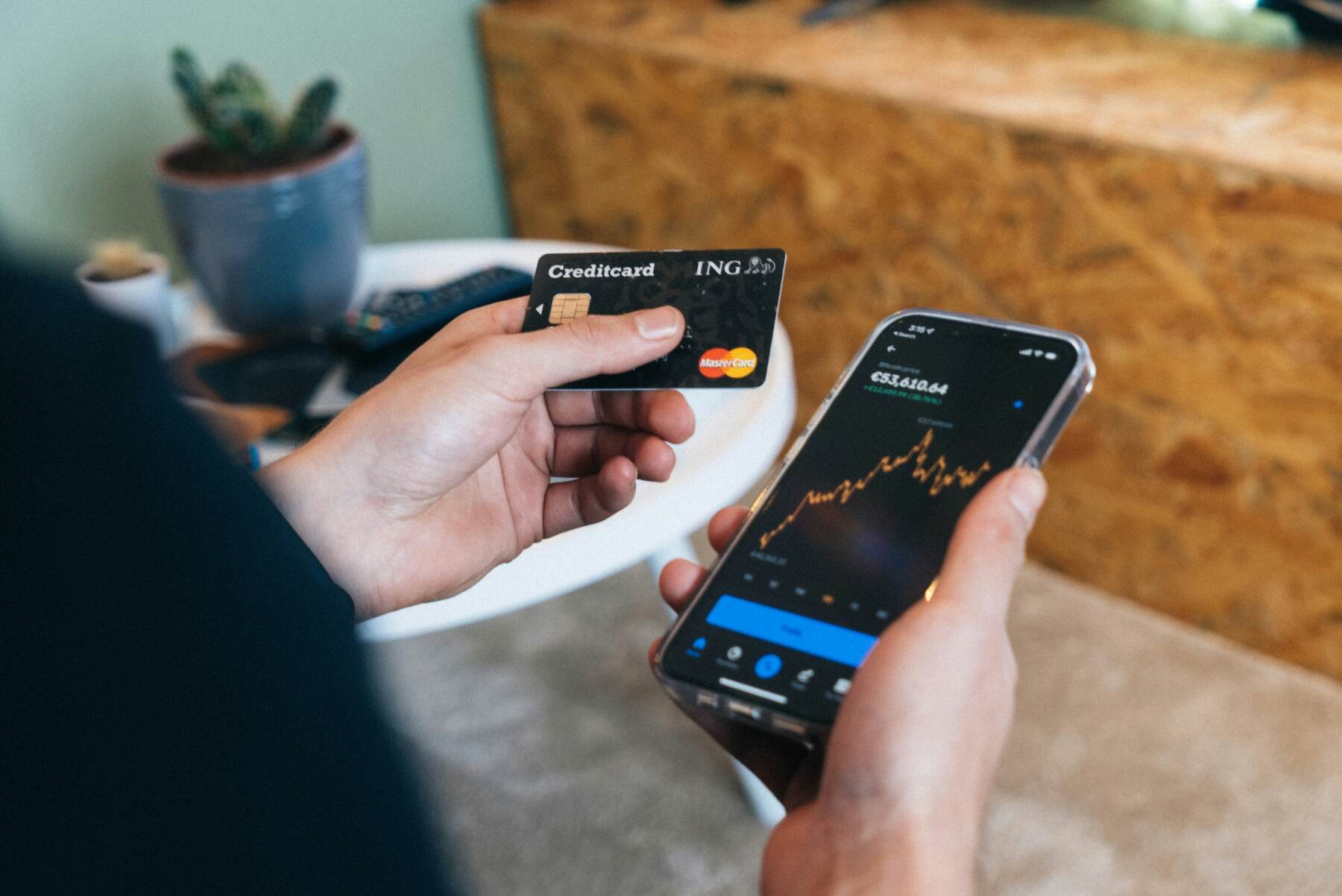 Person holding a credit card and smartphone on both hands