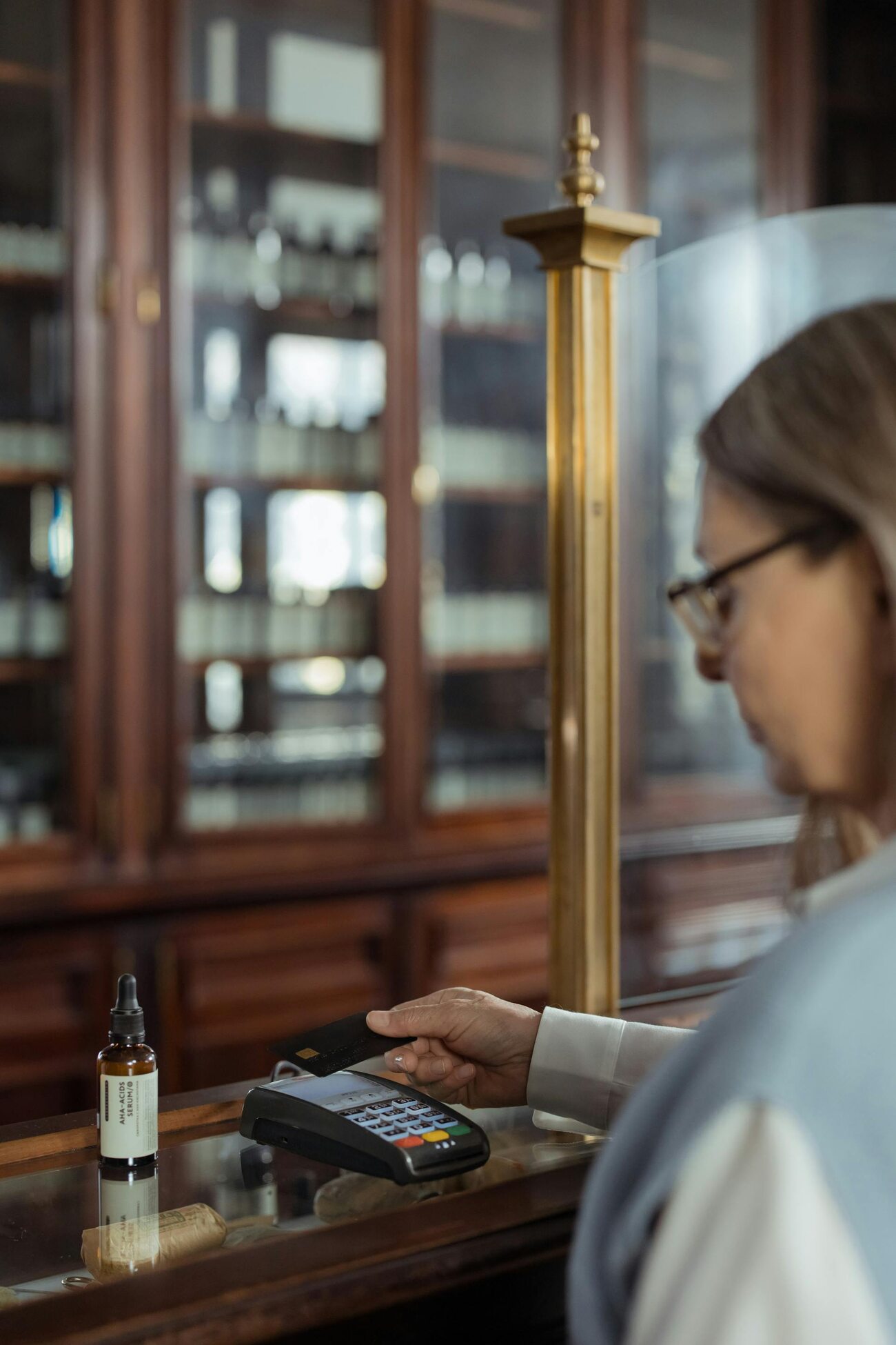 A woman pays for a bottle of serum with her credit card