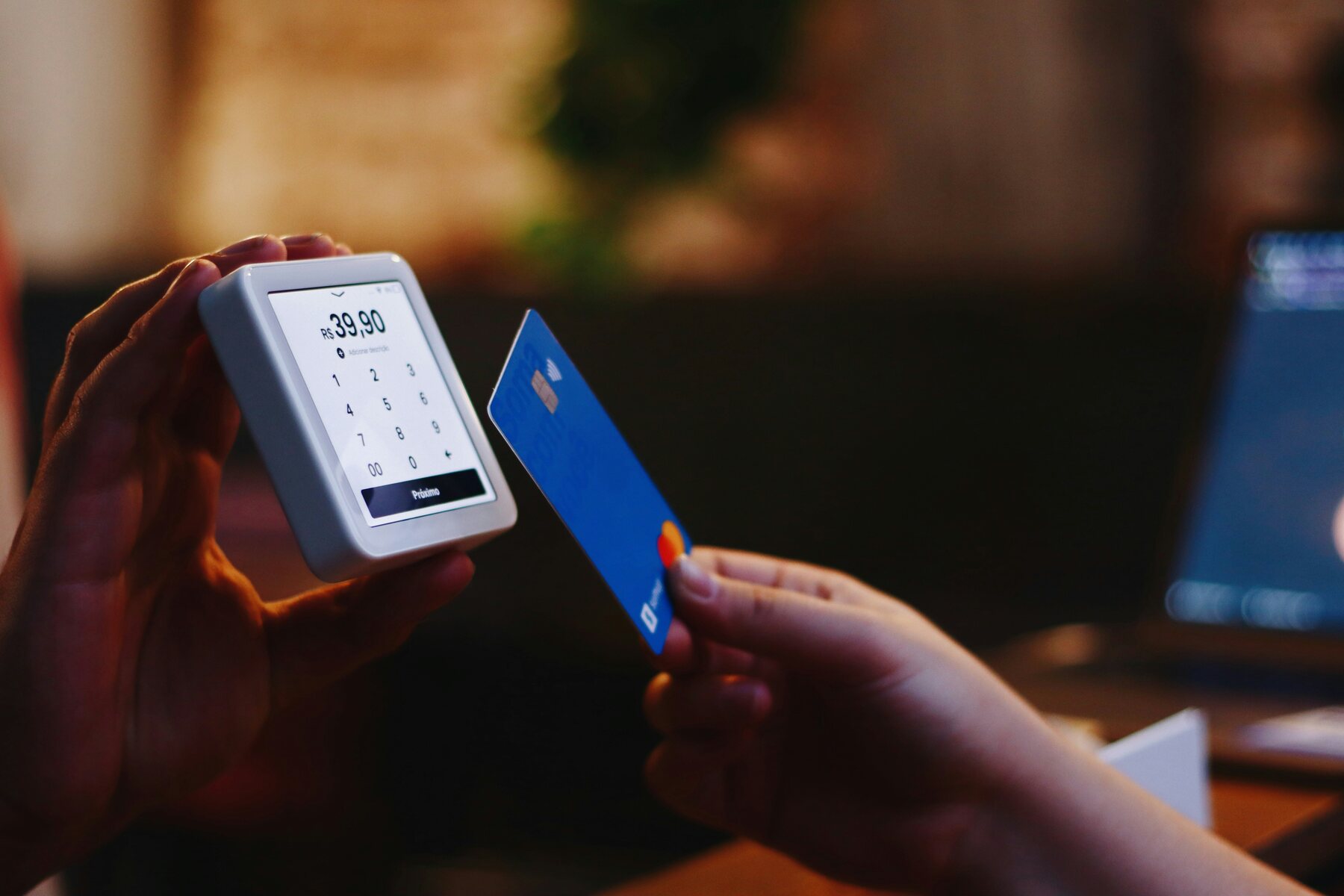 Person tapping a credit card on a portable terminal machine