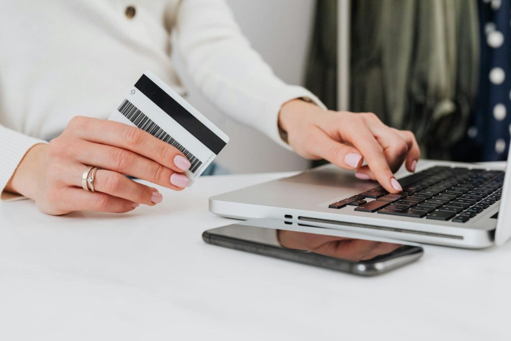 A woman using a laptop while holding a credit card for online transactions