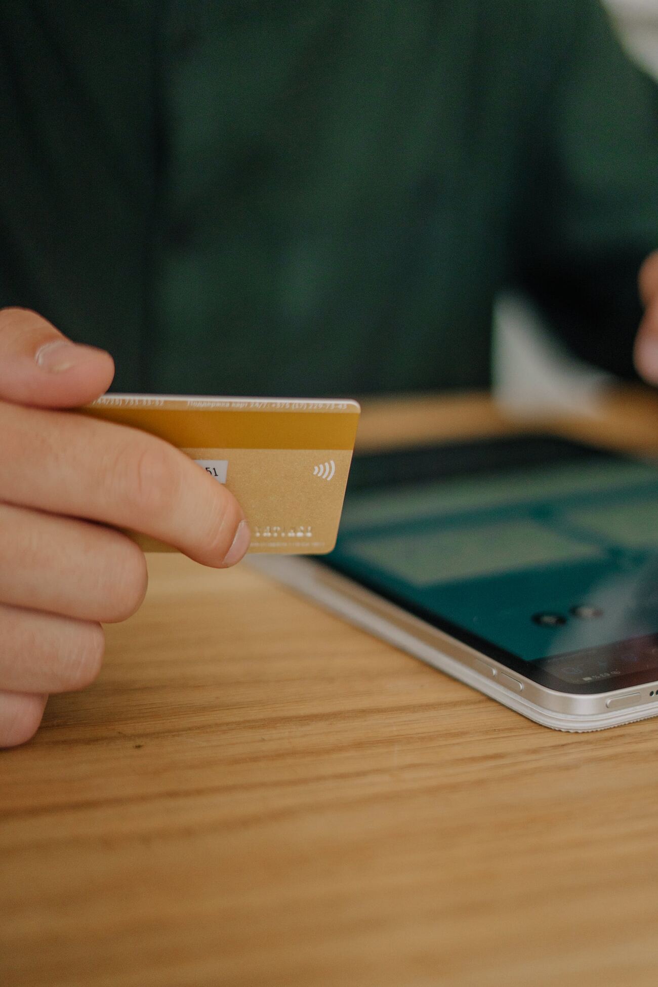 A man holding a credit card while looking at a phone