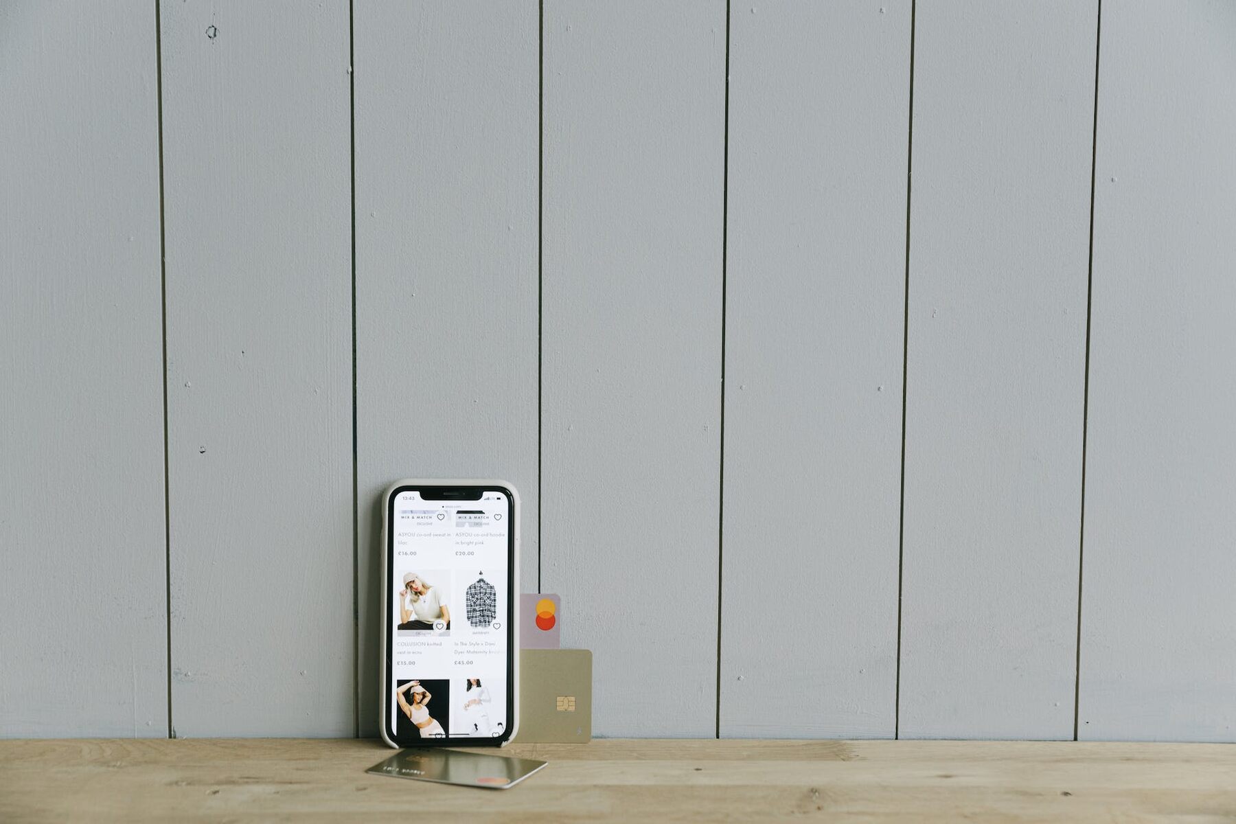 A phone and three credit cards placed against the wall