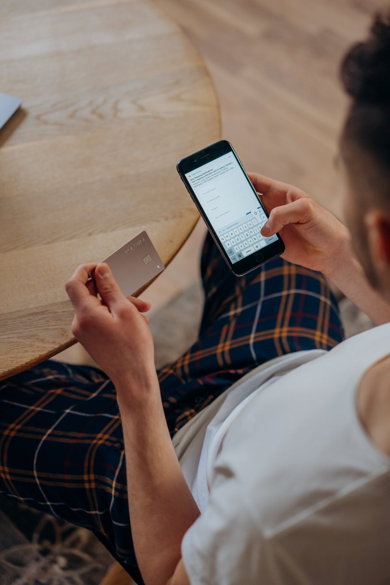 A man holding a phone and a credit card