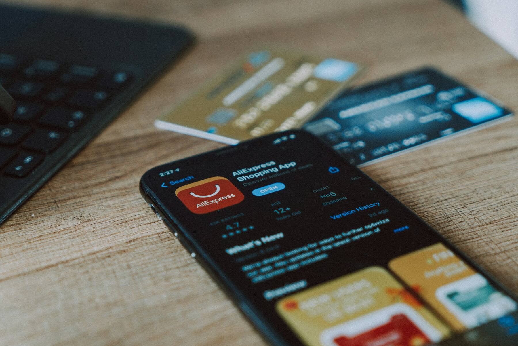 A mobile phone, two credit cards and a laptop on a table