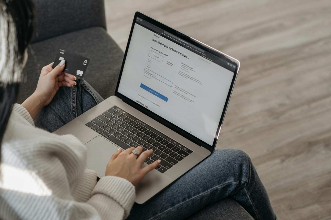 A woman holding her credit card while making an online payment