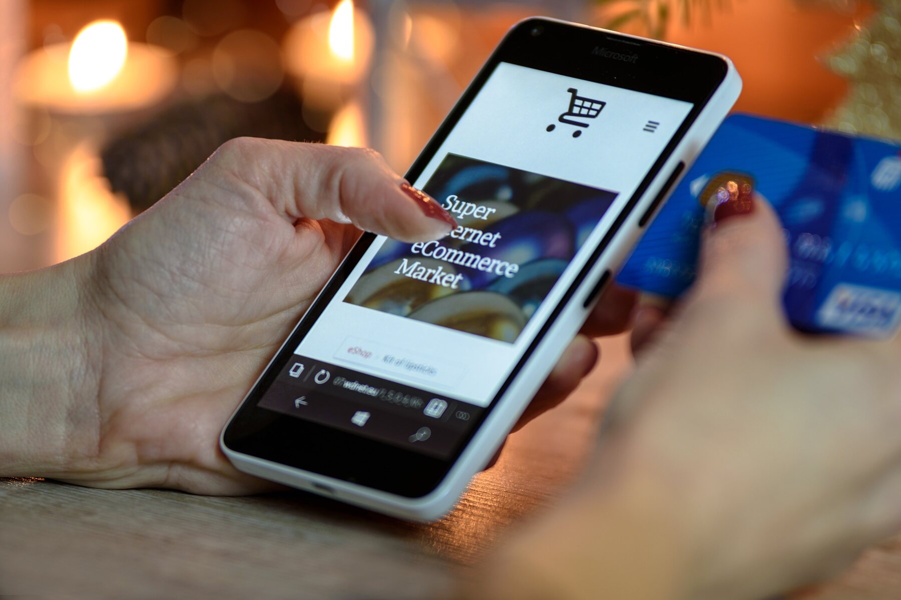 A woman holding a smartphone and a credit card